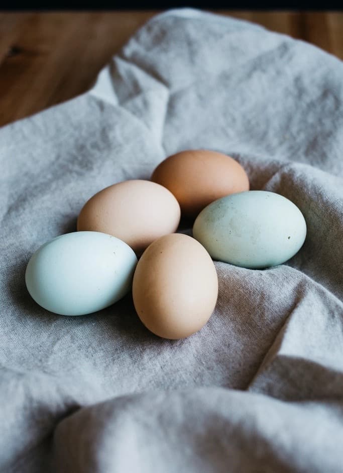 Cinco huevos sobre un paño de lino.